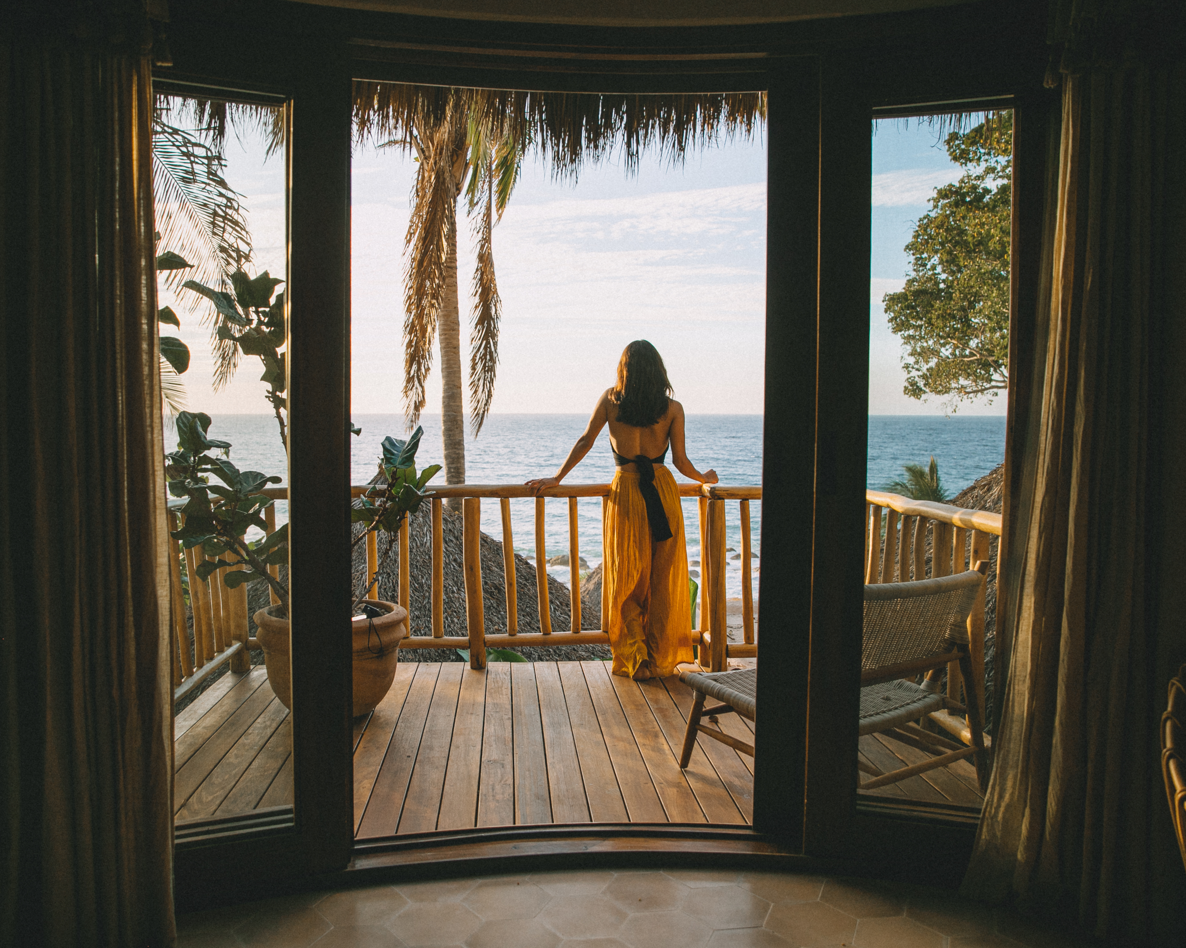 Woman on private bungalow terrace overlooking the ocean